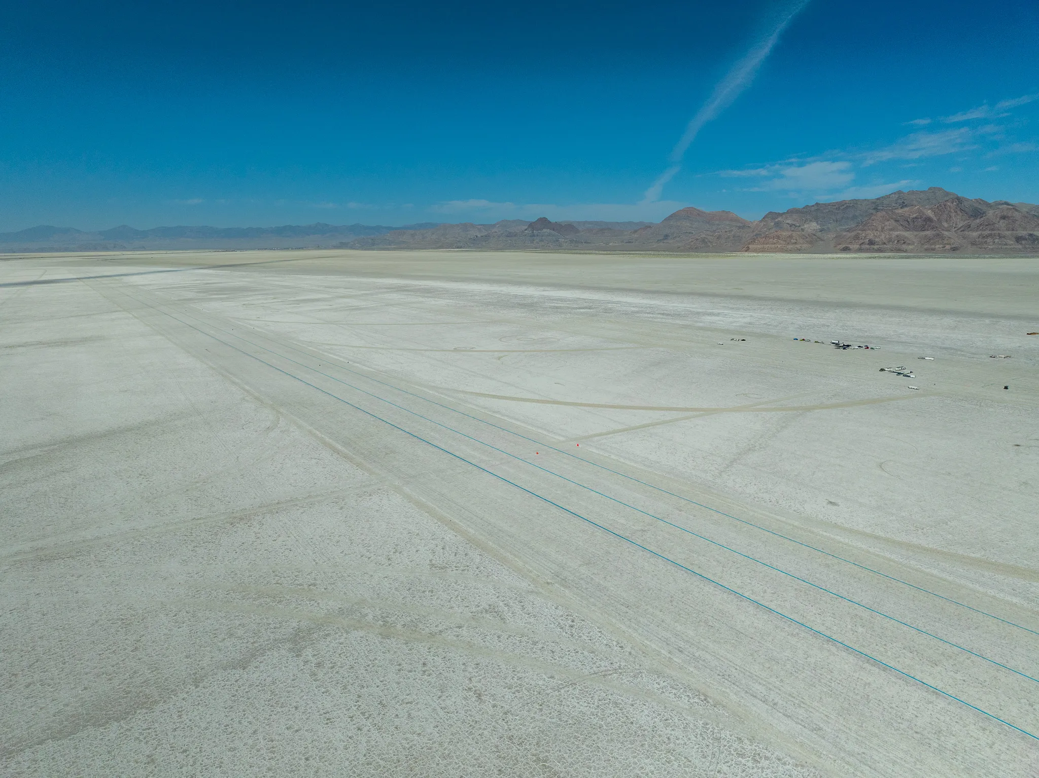 Wide aerial drone photograph of the Bonneville Salt Flats stretching toward distant mountains, Utah