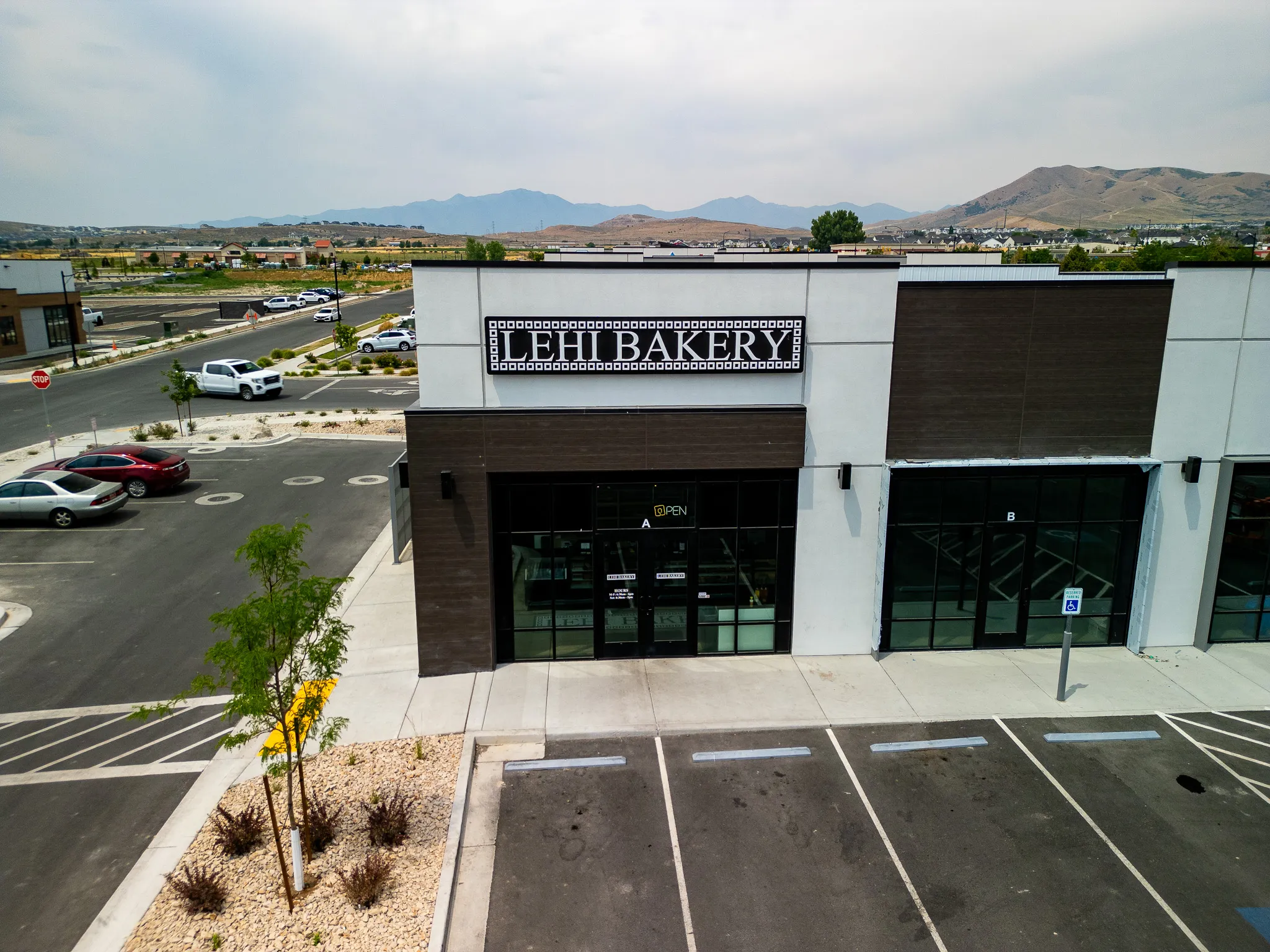 Drone photograph of Lehi Bakery commercial property entrance and parking lot, Lehi, Utah