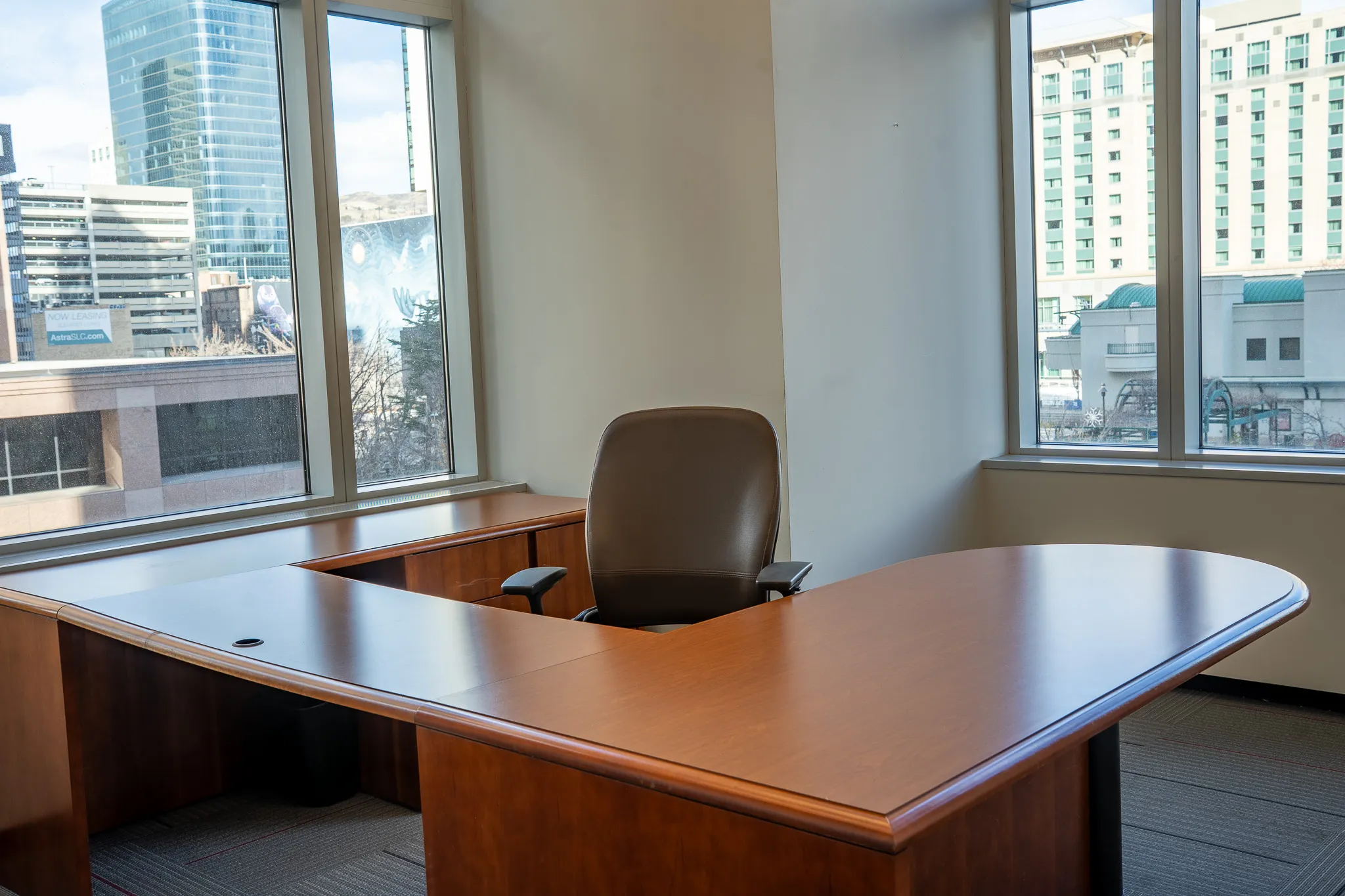Cinematic interior shot looking out an office window onto the downtown Salt Lake City skyline, Utah