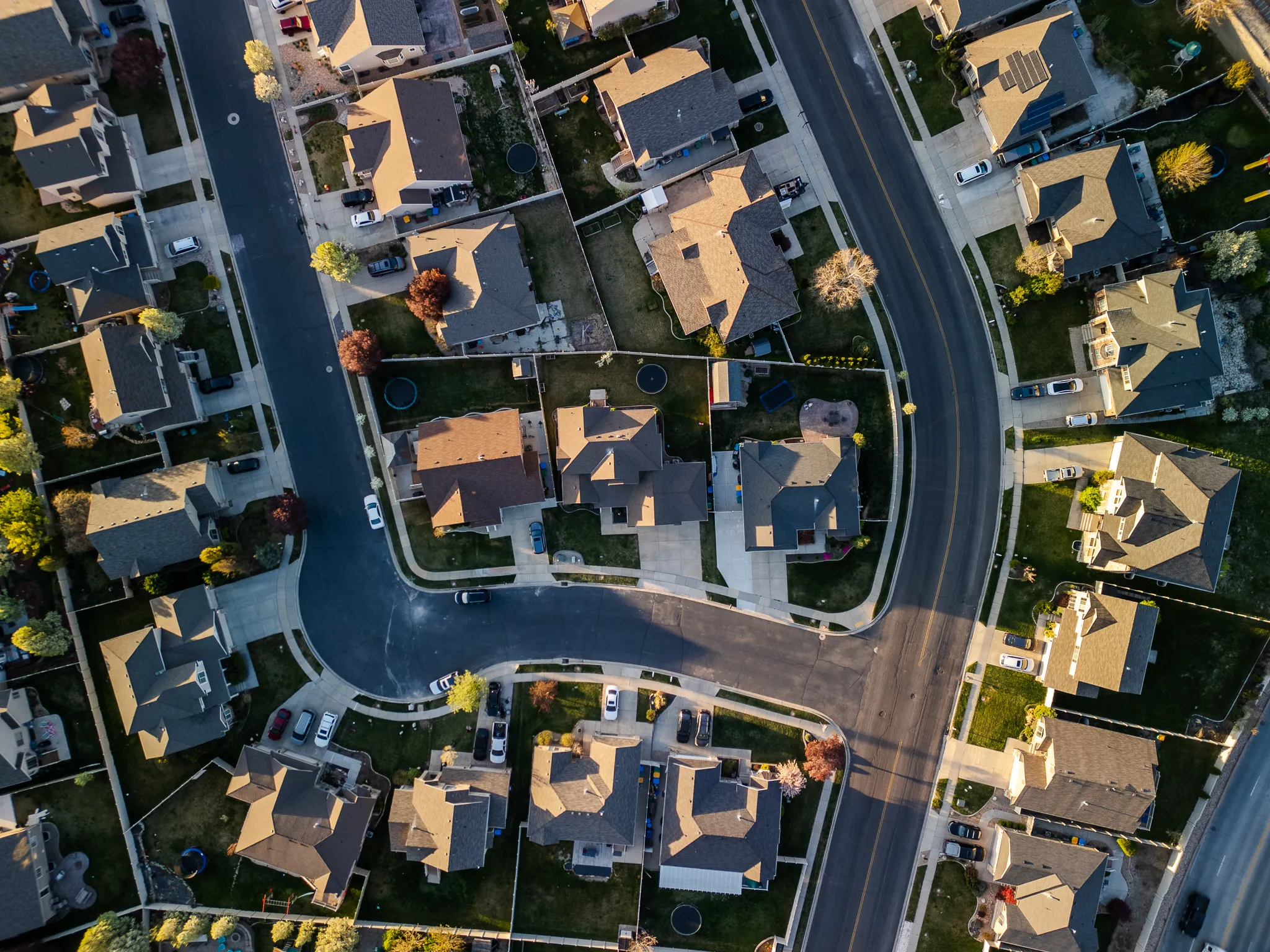 Top-down drone photograph of single-family homes and tree-lined streets in a Salt Lake County neighborhood
