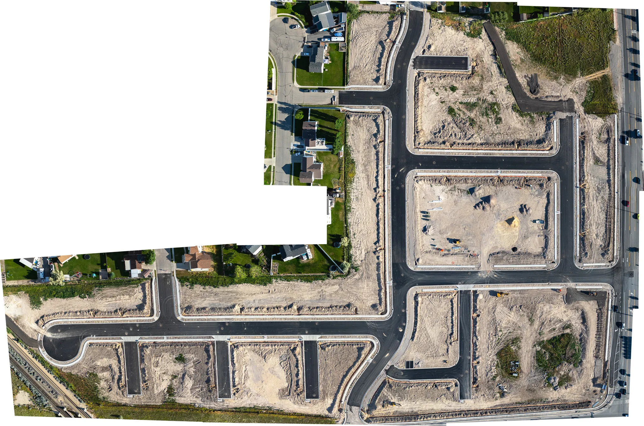Top-down panoramic drone shot of a Utah subdivision under development, showing graded lots and new street layout